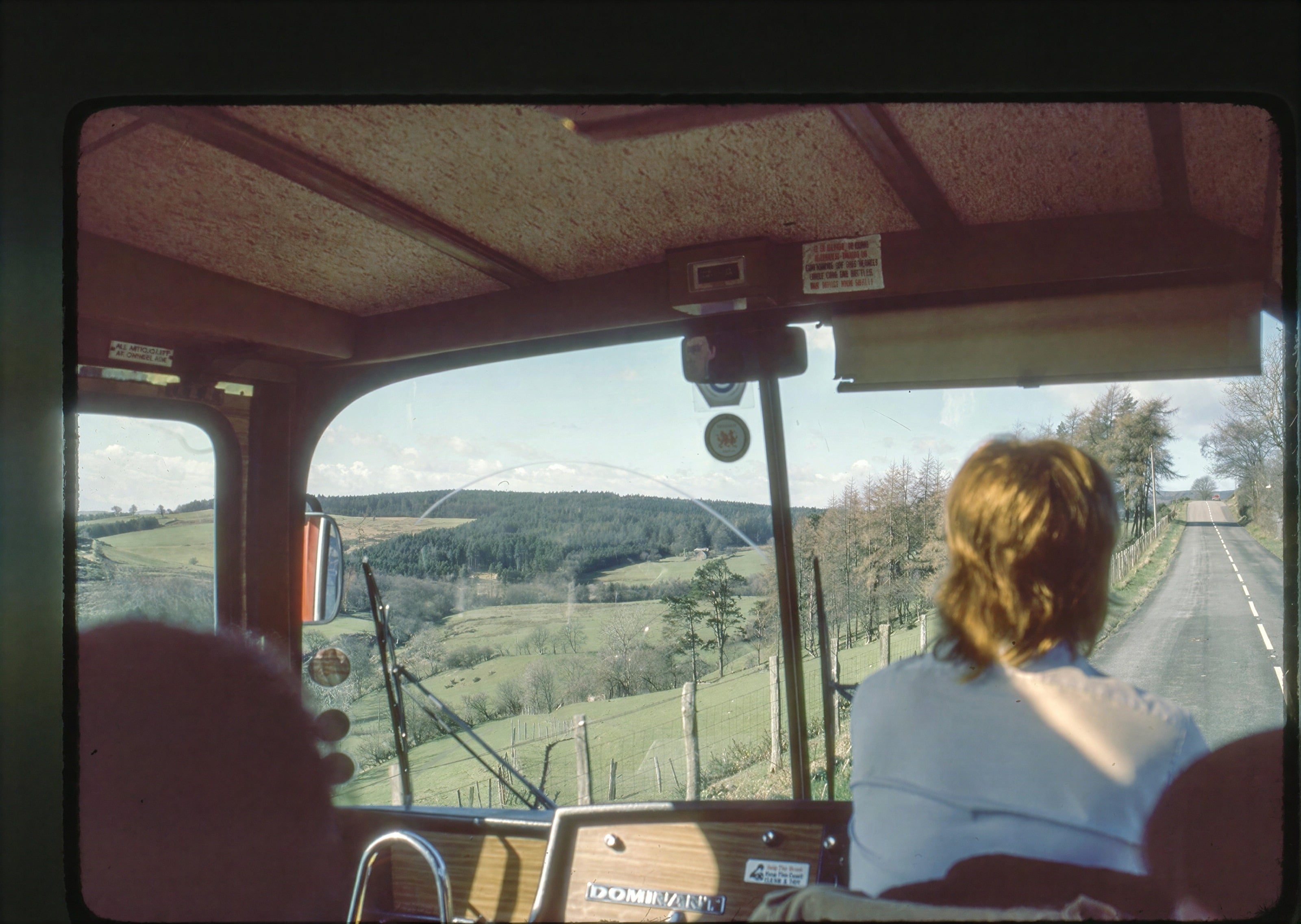 The view from a bus window over green countryside