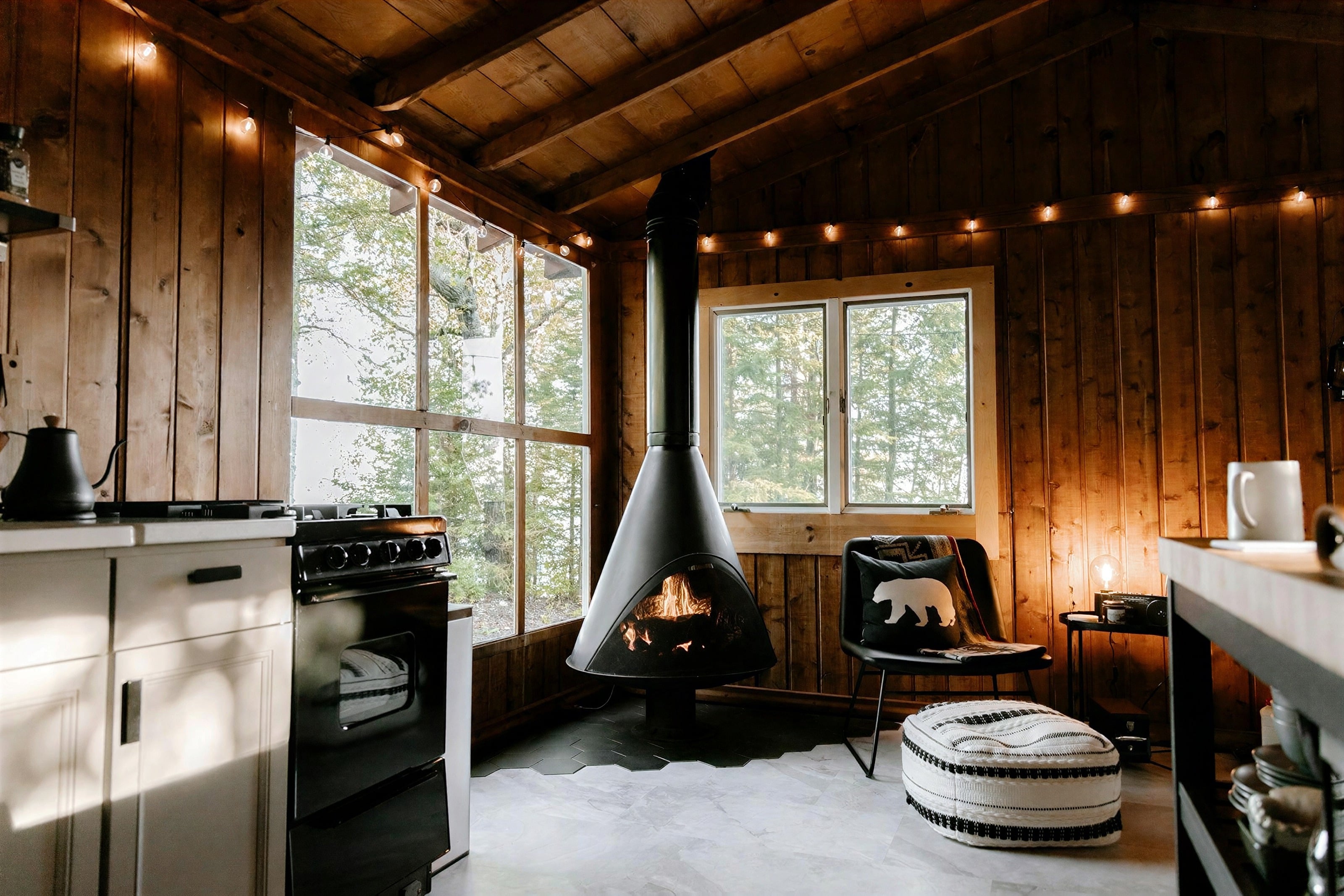 Sjövik Lodge: A wooden lodge living room with a hanging fireplace